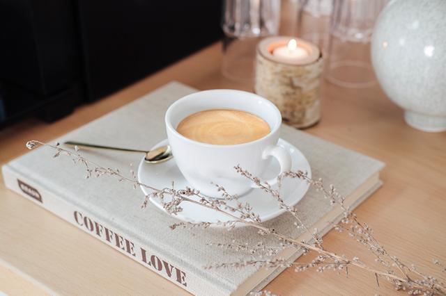 kaffekop med cafe latte på bog fra hotellets kaffeløsning