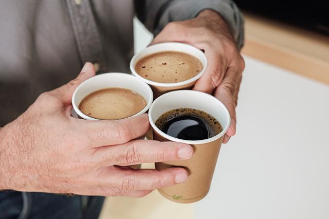 Tre kopper kaffe fra bryganlæg og industrikaffemaskine 